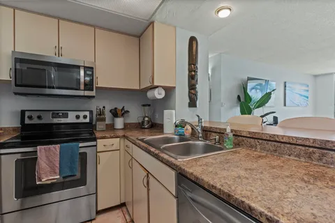 a kitchen with stainless steel appliances granite countertop a sink stove and microwave