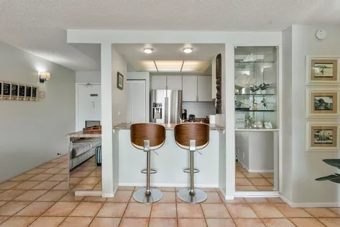 a kitchen with stainless steel appliances kitchen island granite countertop a refrigerator and a sink