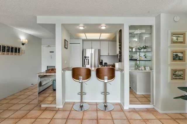 a kitchen with stainless steel appliances kitchen island granite countertop a refrigerator and a sink