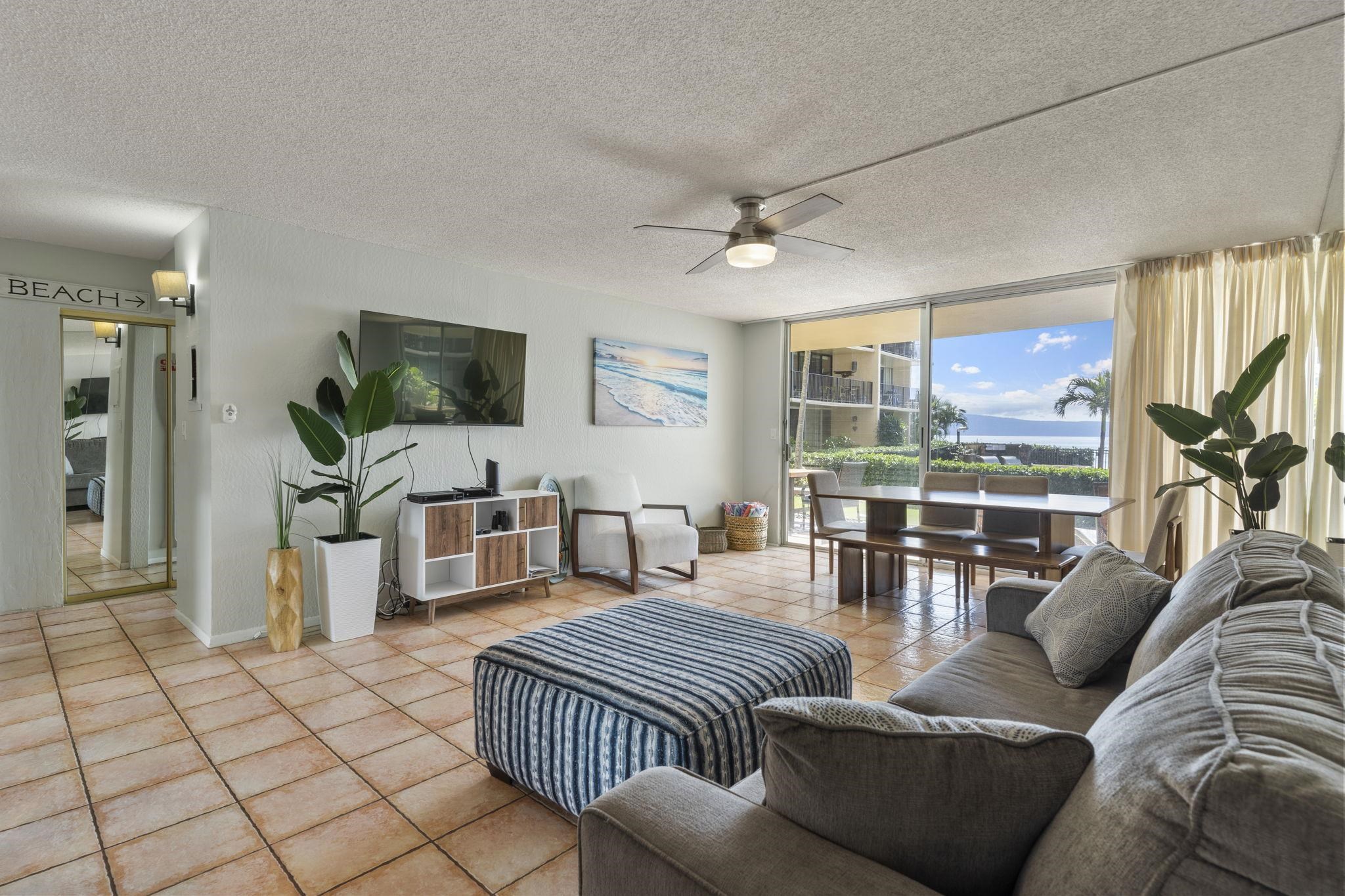 4401 Lower Honoapiilani Road, Unit A101 Lahaina, HI 96761 - Photo 9 of 37 a living room with furniture a flat screen tv and large window