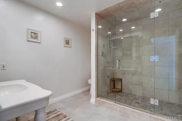 a bathroom with a sink a toilet and shower