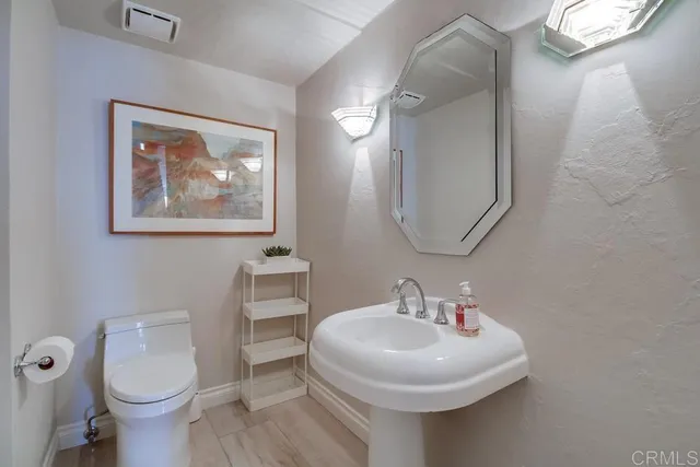 a bathroom with a toilet a sink and mirror