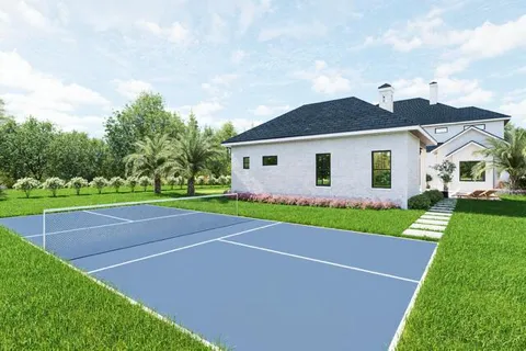 a view of a yard in front of a house with plants and large tree