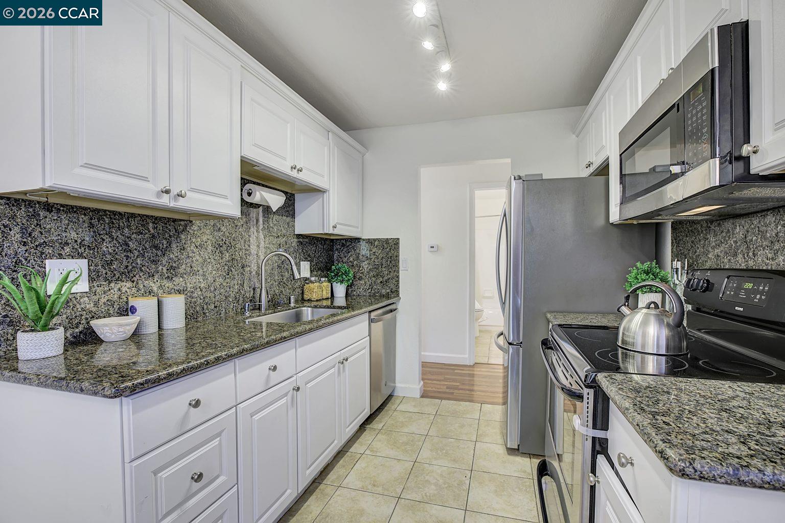 2650 Jones Road, Unit 14 Walnut Creek, CA 94597 - Photo 12 of 44 a kitchen with stainless steel appliances granite countertop a sink stove and refrigerator