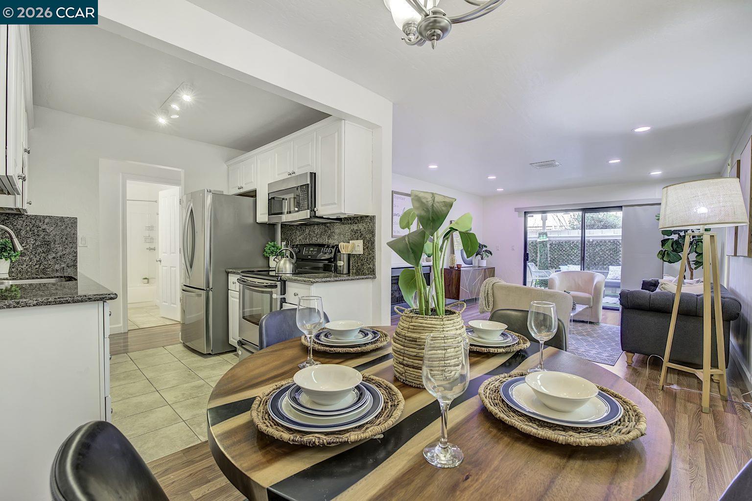 2650 Jones Road, Unit 14 Walnut Creek, CA 94597 - Photo 8 of 44 a kitchen and a dining table with wooden floor