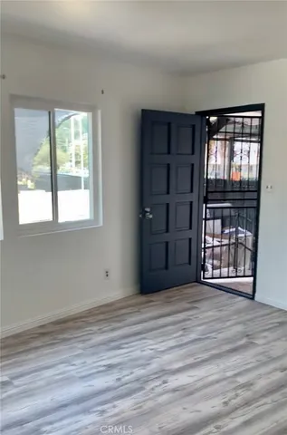 a view of a white house with large windows and a small yard