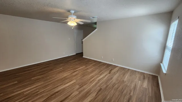 a view of a room with wooden floor and white walls