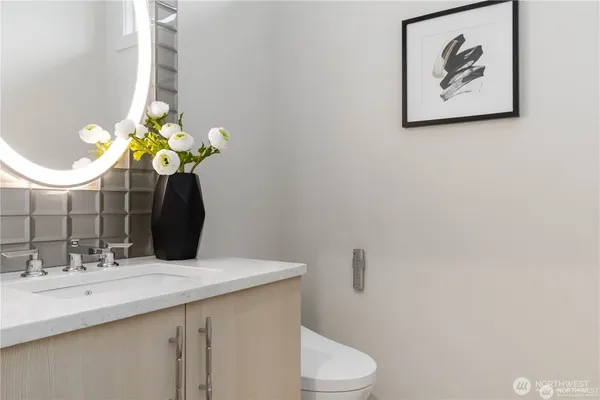 a bathroom with a sink a toilet and a mirror