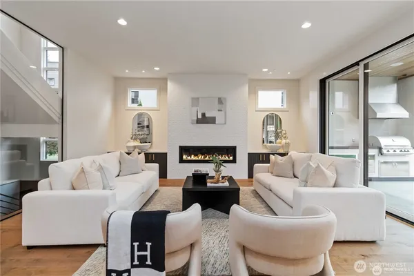 a living room with furniture a large window and a fireplace