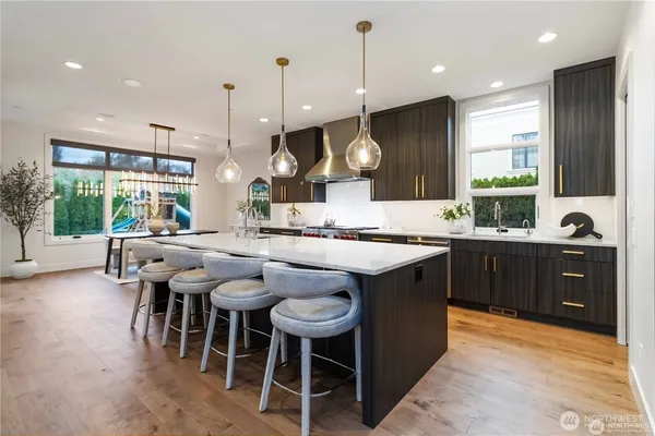 a kitchen with a sink a counter top space a large center island and stainless steel appliances