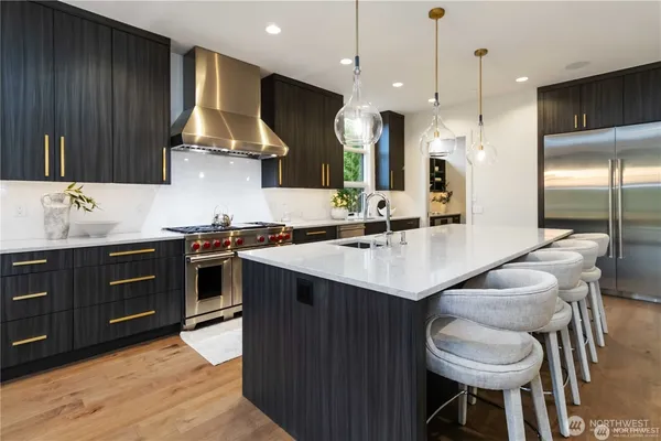 a kitchen with stainless steel appliances granite countertop a sink a stove and a refrigerator