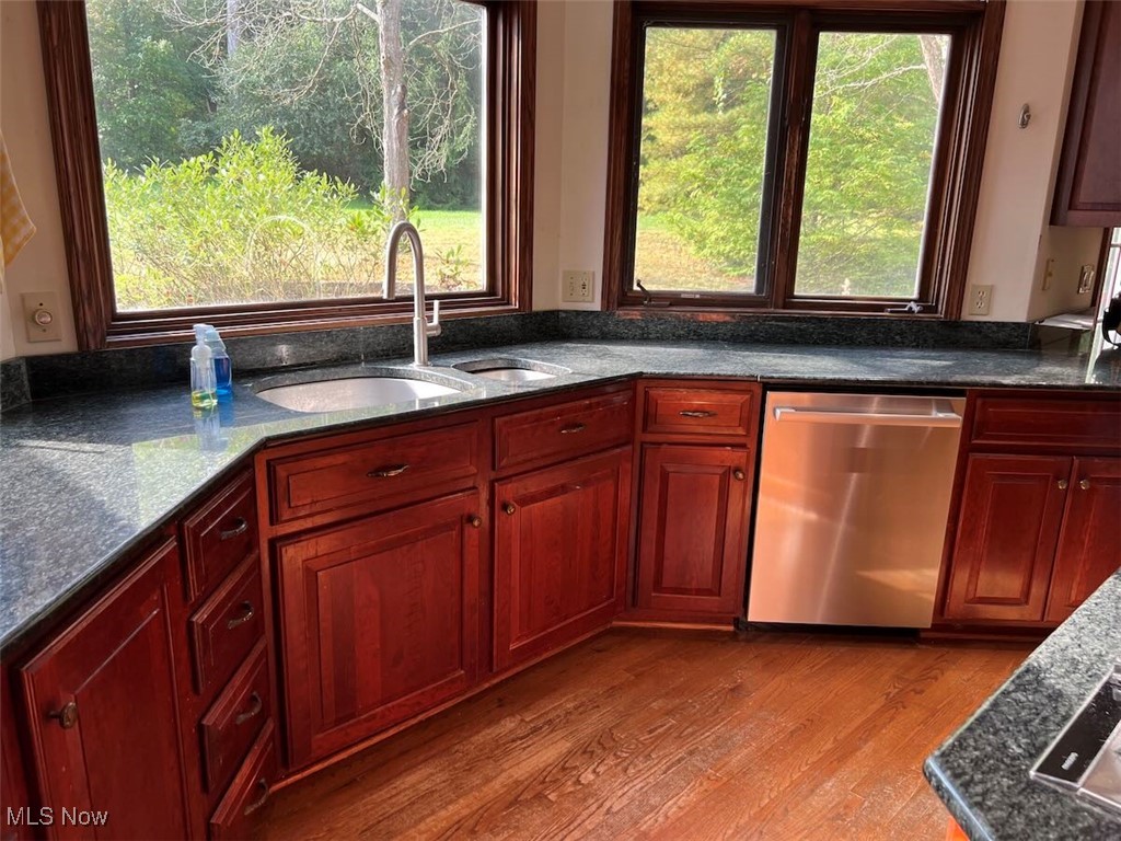 7060 Gates Road Gates Mills, OH 44040 - Photo 11 of 38 Kitchen featuring dark stone countertops, stainless steel dishwasher, wood finished floors, and reddish brown cabinets