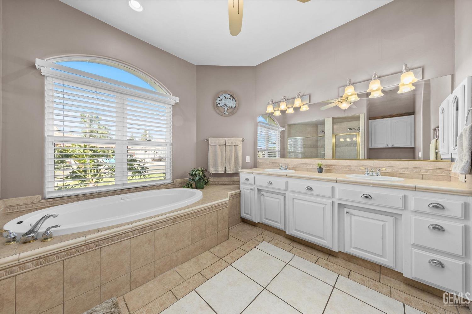 Undisclosed Address Bakersfield, CA 93314 - Photo 16 of 34 a spacious bathroom with a granite countertop tub sink and mirror