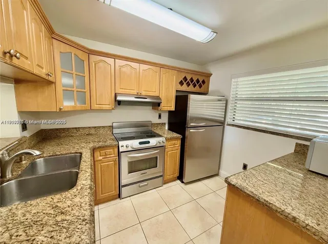 a kitchen with stainless steel appliances granite countertop a sink stove and refrigerator
