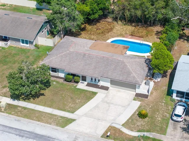 an aerial view of a house with swimming pool and a yard