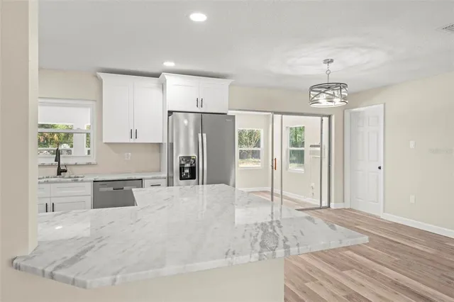 a kitchen with white cabinets appliances and sink