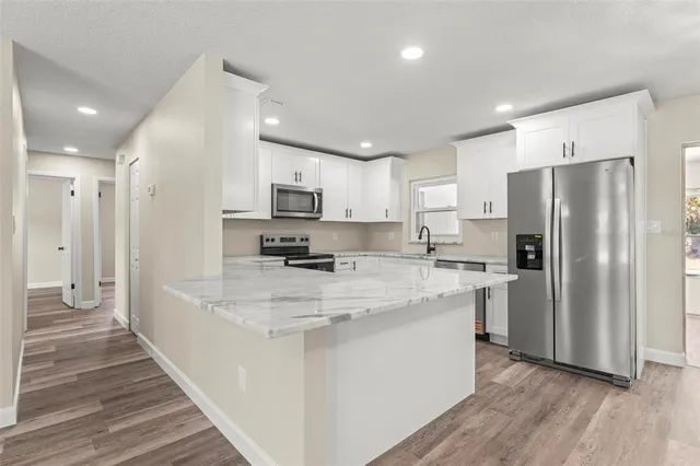 a kitchen with granite countertop white cabinets and white appliances