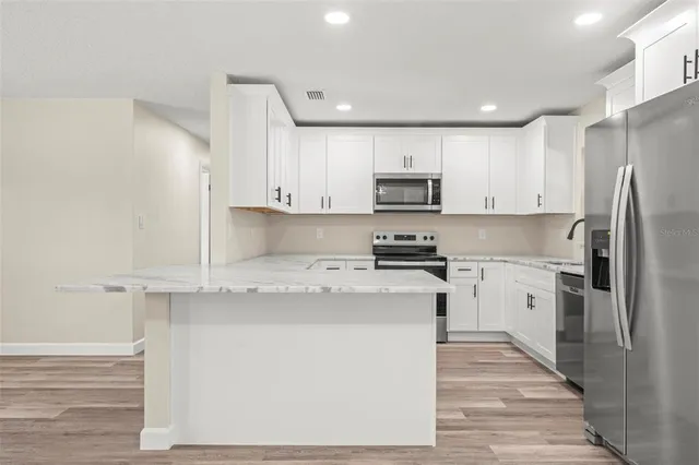 a kitchen with granite countertop white cabinets and a sink