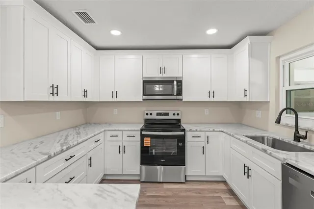 an empty room with window ceiling fan and wooden floor