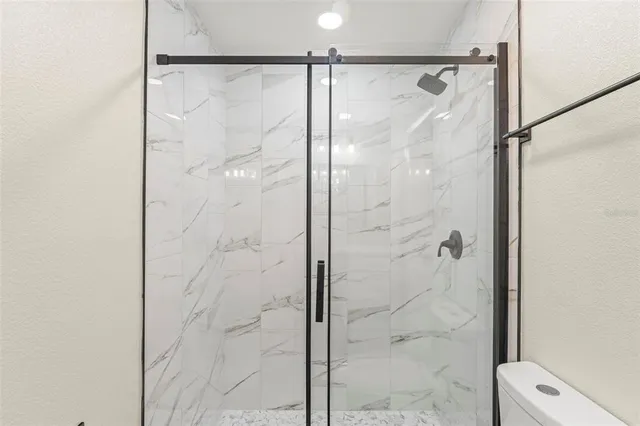 an empty room with a window and a ceiling fan