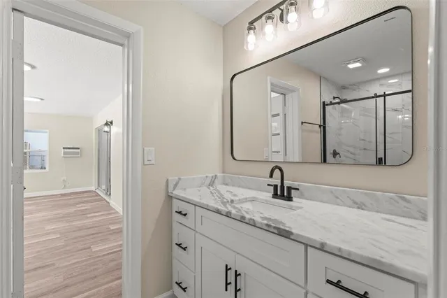 an empty room with wooden floor and a ceiling fan
