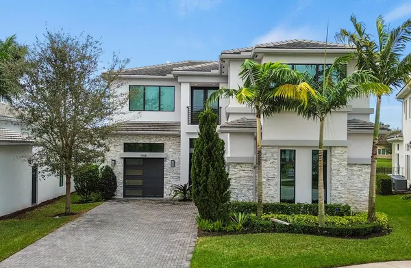 a front view of a house with a yard and a garage