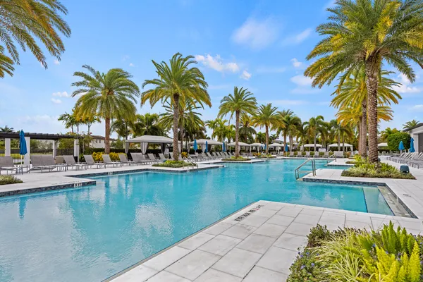 a view of swimming pool with outdoor seating and house in the background