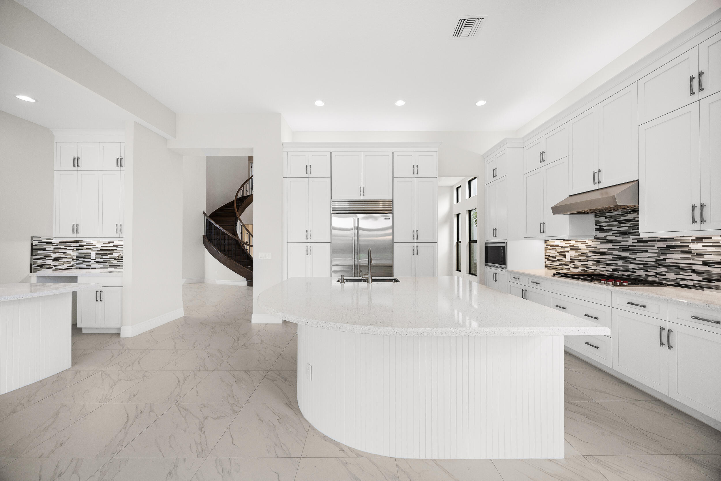 9168 Benedetta Place Boca Raton, FL 33496 - Photo 6 of 51 a large white kitchen with stainless steel appliances kitchen island a large counter top and a stove