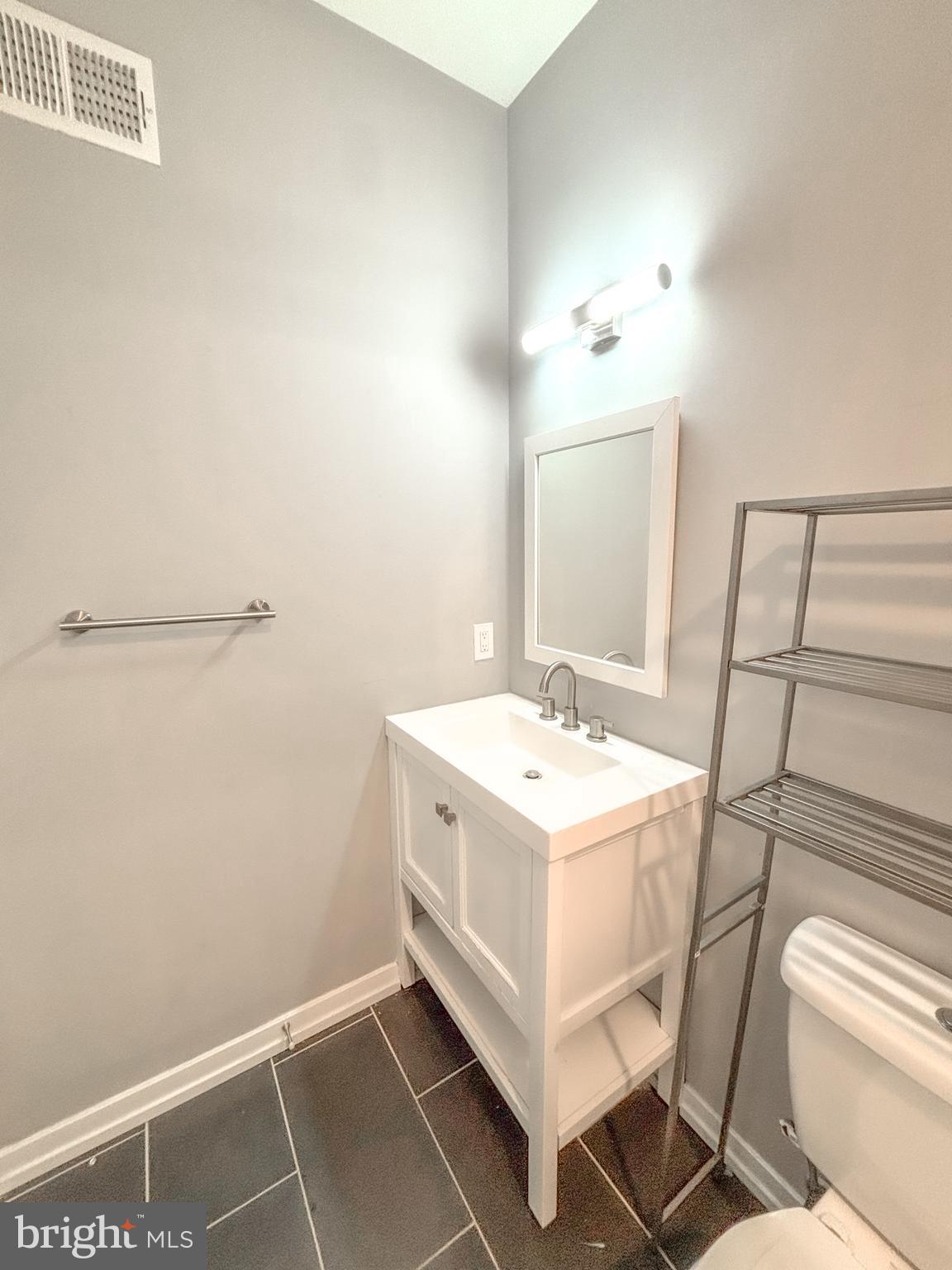 2426 Jasper Street, Unit A Philadelphia, PA 19125 - Photo 12 of 19 a bathroom with a sink a toilet and mirror