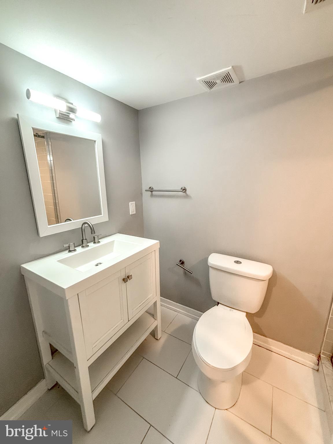 2426 Jasper Street, Unit A Philadelphia, PA 19125 - Photo 15 of 19 a bathroom with a white toilet sink and mirror