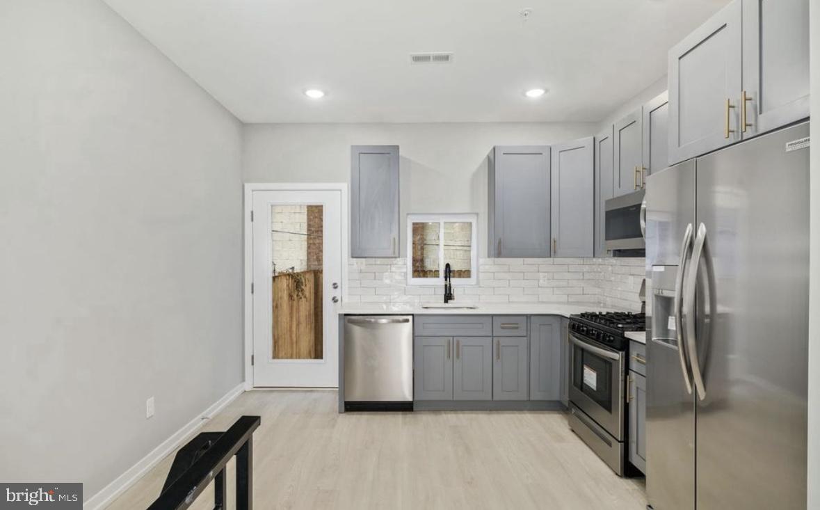 2426 Jasper Street, Unit A Philadelphia, PA 19125 - Photo 4 of 19 a kitchen with stainless steel appliances a refrigerator sink and stove
