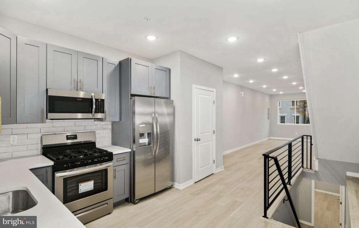 2426 Jasper Street, Unit A Philadelphia, PA 19125 - Photo 5 of 19 a kitchen with stainless steel appliances kitchen island granite countertop a stove a refrigerator and a microwave