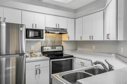 a kitchen that has a sink and a stove top oven