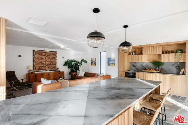 a living room with stainless steel appliances kitchen island granite countertop furniture and a kitchen view
