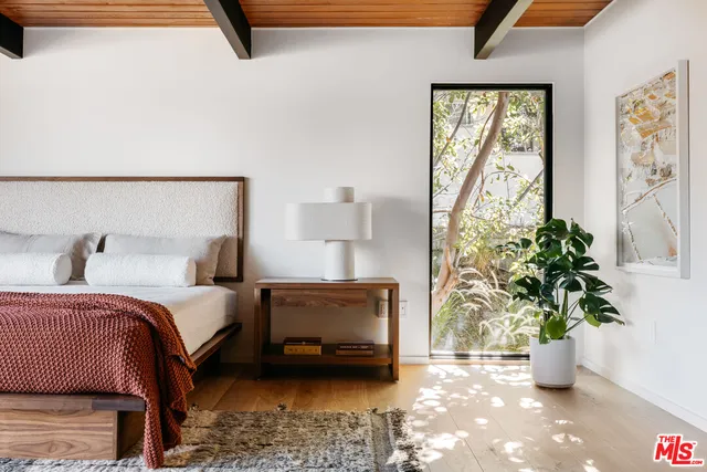 a spacious bedroom with a bed and a chandelier