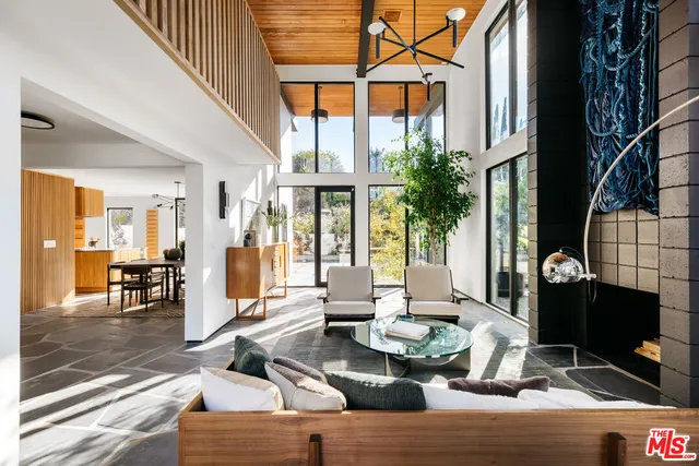 a living room with fireplace furniture and a floor to ceiling window