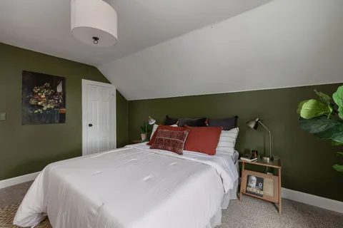 a bedroom with a bed and a painting on the wall