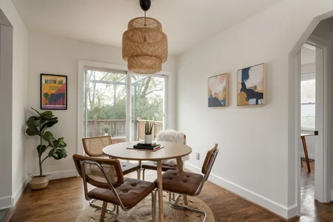 a dining room with furniture a chandelier and wooden floor