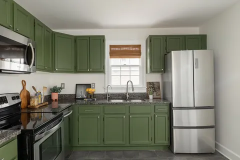 a kitchen with stainless steel appliances granite countertop a refrigerator and a stove top oven