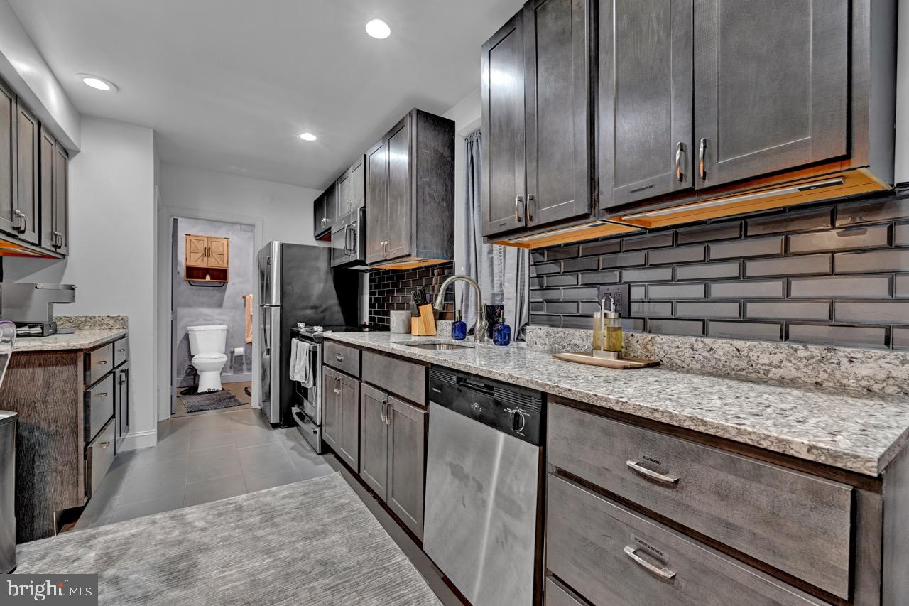 1709 Bank Street Baltimore, MD 21231 - Photo 33 of 49 a kitchen with granite countertop stainless steel appliances and sink