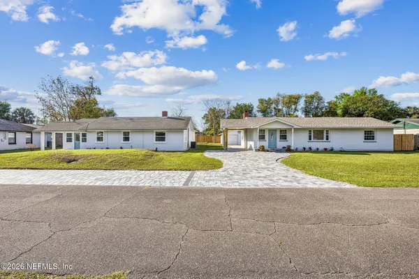a view of house that has a large tree in front of it