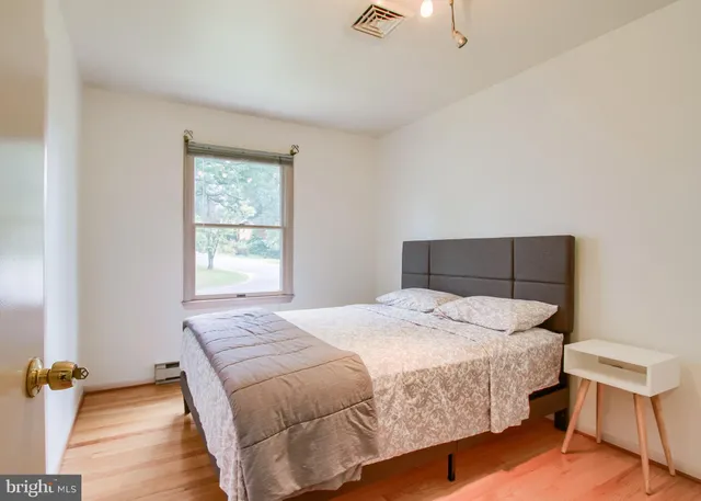 a bedroom with a bed and wooden floor