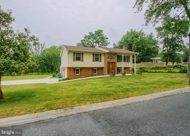 a view of a house with a yard and tree s