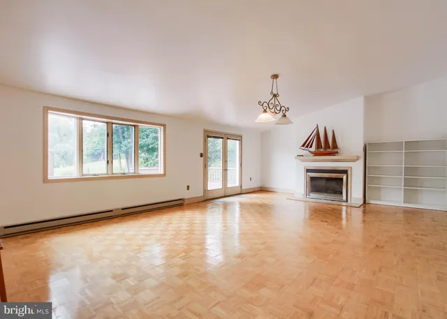 an empty room with fireplace and windows
