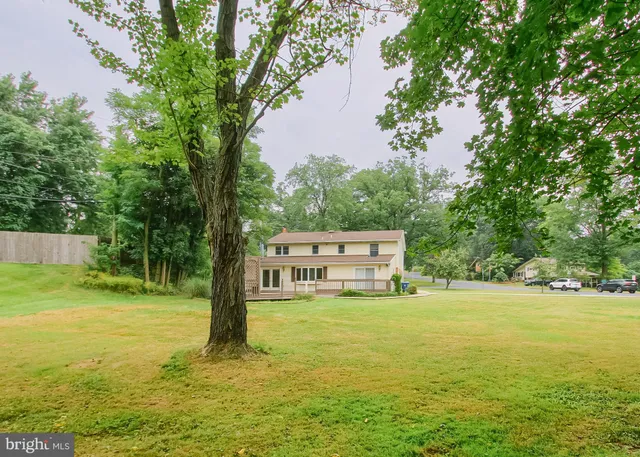 a view of a house with a big yard and palm trees