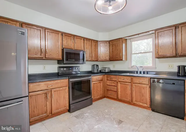 a kitchen with stainless steel appliances granite countertop a stove sink and cabinets