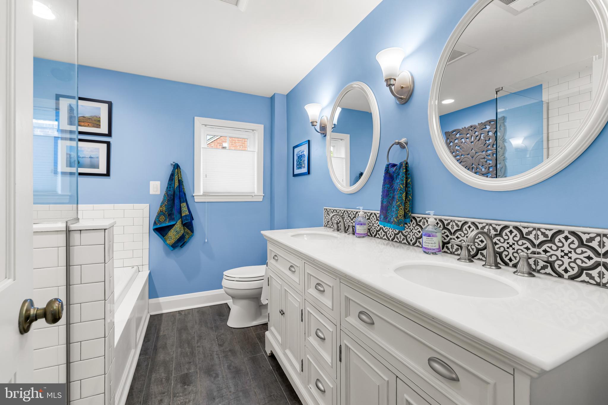 700 Regester Avenue Baltimore, MD 21212 - Photo 29 of 43 a bathroom with a granite countertop toilet a sink and a mirror