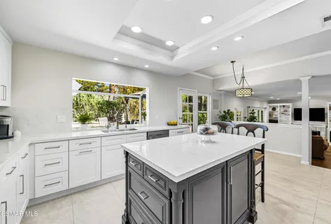 a kitchen with granite countertop a sink a center island and stainless steel appliances