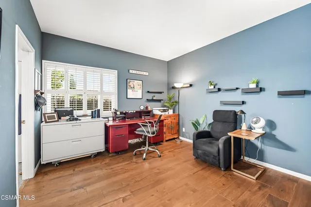a view of a workspace with furniture and a window