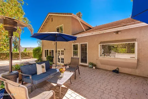 a patio with couches under an umbrella